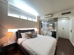 a bedroom with a bed with a lamp and a mirror at Yuexi, Nordic style, Shanghai Railway Station, Changshou Road subway, cooking, big bathtub, family outing, Disney, the Bund, Nanjing Road Walkway, Hongshoufang in Shanghai
