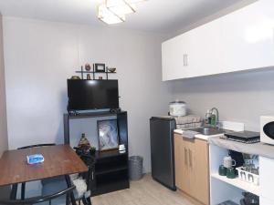 a kitchen with a sink and a black refrigerator at Amaia Steps Condominium Studio -across Ayala Mall Capitol Central in Bacolod +9 photos