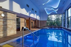 a large swimming pool in a large room at Mercure Bale Mulhouse Aeroport in Blotzheim
