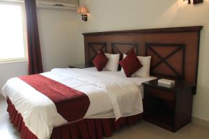 a bedroom with a large bed with white and red pillows at APARTMENT near GULF DELMON in Dammam