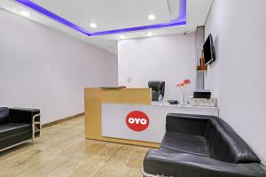 a waiting room with two chairs and aype sign on the wall at Hotel O Fox Guest House in Greater Noida