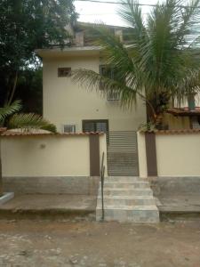 a house with a palm tree in front of it at Recanto dos sabias AP01 in Conservatória