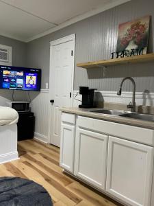 a kitchen with a sink and a tv on the wall at Brooklyn's Tiny Apartment Pets Welcome in North Little Rock