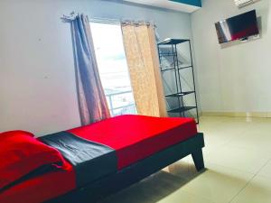 a bedroom with a red bed and a window at Hotel Zabdy in Liberia