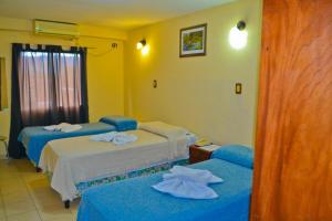 a hotel room with two beds with towels on them at Hotel Ke Kuul in Salta