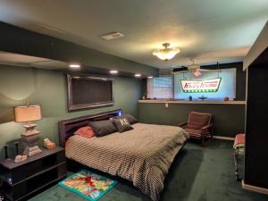 a bedroom with a large bed and a television at FIFA Basecamp with 2 Kitchens, 5BR, 4 Baths in Roeland Park
