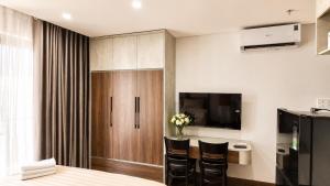 a room with a table and chairs and a tv at Marly Apartment in Danang