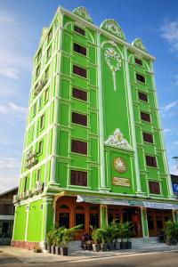 a green building with plants in front of it at Phetchalern serviced apartment in Vientiane