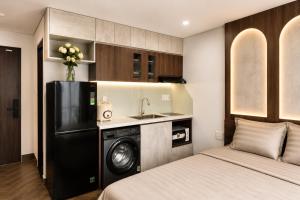 a bedroom with a bed and a washing machine in a kitchen at Marly Apartment in Danang +11 photos