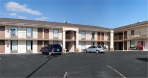 two cars parked in a parking lot in front of a motel at Parkway Inn in Morristown