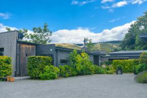 a house with bushes in front of it at Ballymoney Cnoc in Tai Tapu +28 photos