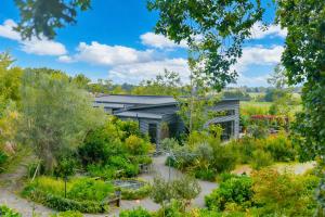 a garden in front of a building with plants at Ballymoney Cnoc in Tai Tapu