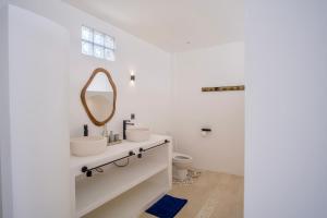 a white bathroom with a sink and a mirror at NEW! 2BR Ocean View, Infinity Pool, Villa Kerylos in Sampalan +24 photos