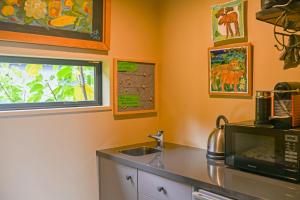 a kitchen with a sink and a microwave at Ballymoney Cnoc in Tai Tapu