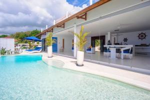 a swimming pool in front of a house at NEW! 2BR Ocean View, Infinity Pool, Villa Kerylos in Sampalan