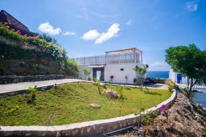 a house with a garden on the side of a hill at NEW! 2BR Ocean View, Infinity Pool, Villa Kerylos in Sampalan
