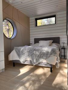 a bedroom with a bed with a gray blanket and a window at The Lake Villa in Ingramport