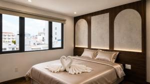 a bedroom with two swans sitting on a bed at Marly Apartment in Danang
