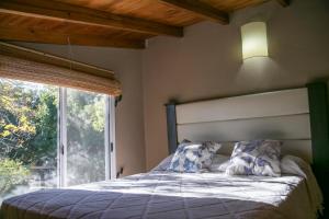 a bedroom with a bed with a large window at El Solar in Vuelta de Obligado
