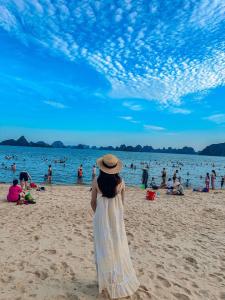 a woman in a straw hat standing on a beach at Sao Mai Hotel Hạ Long in Ha Long
