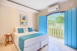 a bedroom with a bed and a large window at Pousada Eclipse Paraty in Paraty