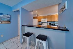 a kitchen with two stools at a counter in a room at Siesta Key Beach - 2 Bedroom - 3 Beds - 3 Bathroom Duplex with Heated Swimming Pool in Siesta Key