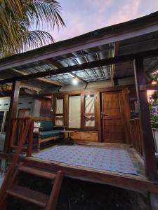 a house with a wooden door and a porch at Kondo Villa in Labuhanpandan