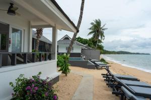 a house on the beach with chairs and flowers at The Cosy Maenam Beach Resort in Mae Nam