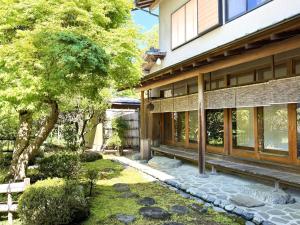 a house with a stone walkway next to a tree at ccb hotel 90Minutes from Tokyo in Chichibu