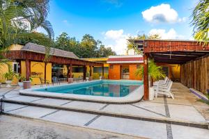 a house with a swimming pool next to a building at Hotel Scarlette in Tulum