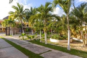 a park with palm trees and a building at Hotel Scarlette in Tulum