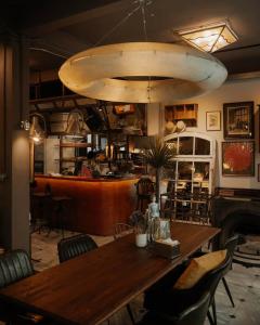 ein Esszimmer mit einem Holztisch und einer großen Lampe in der Unterkunft Brown H in Pom Prap