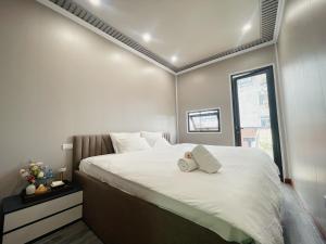a bedroom with a large white bed with a window at Hanoi Quarter Life Hostel in Hanoi