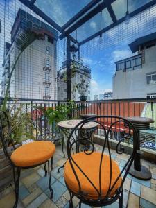 a patio with tables and chairs on a balcony at Hanoi Quarter Life Hostel in Hanoi