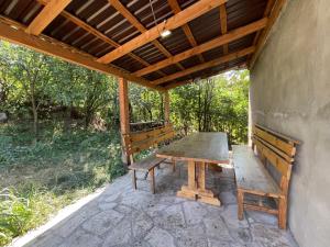 a wooden table and benches on a patio at Jelini Villa in Dilijan