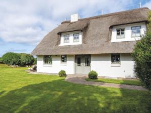 a large white house with a thatched roof at Leuchtturmblick-Sued in Kampen
