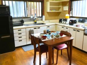 a kitchen with a wooden table and a small table with dishes on it at ccb hotel 90Minutes from Tokyo in Chichibu