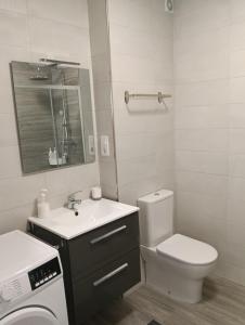 a white bathroom with a toilet and a sink at Piso Gallega in Finisterre +26 photos