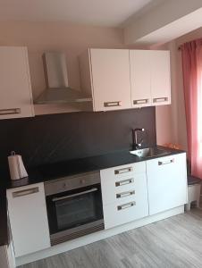 a kitchen with white cabinets and a sink at Piso Gallega in Finisterre