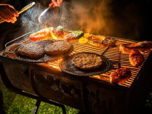a grill with hamburgers and other food on it at Rainbow Safari & Lodge in Udawalawe