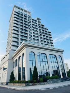 a large white building with a large tall building at Homestay- Phòng nghỉ Lazur Cửa Lò in Giáp Vinh Yên