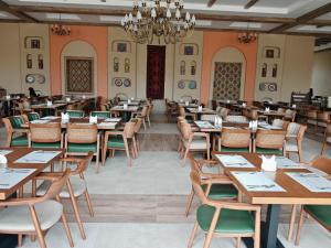 a dining room with tables and chairs and a chandelier at Arda Turan in Khiva