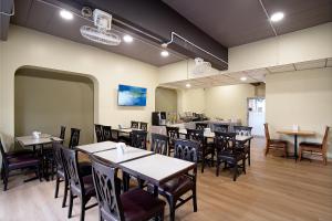 a restaurant with tables and chairs in a room at Synsiri Lat Phrao 83 in Ban Zong Katiam