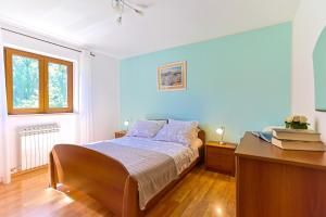 a bedroom with a bed and a dresser and a desk at Family Villa Krizanci Istria in Žminj +33 photos