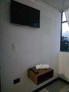 a living room with a television on a wall with a table at Hotel Casa Palma in La Mesa +27 photos