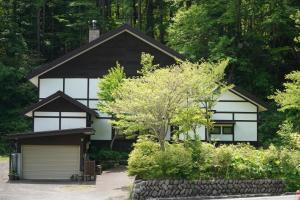 a white and black house with a garage at リトリート奥入瀬屋 in Towada