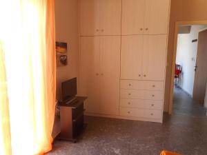 a room with a desk and cabinets and a television at ComeHome in Heraklio Town