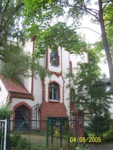 an old house with a fence in front of it at Lilienthalschlösschen in Berlin +1 photo