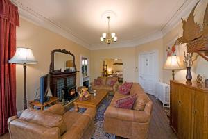a living room with two couches and a tv at Knap Guest House in Tarbert