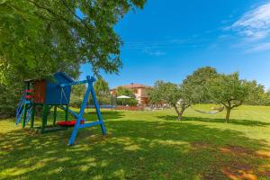 a playground with a blue slide in a park at Family Villa Krizanci Istria in Žminj
